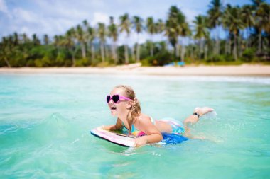 Çocuklar tropik sahilde sörf. Çocuk ile tatil.