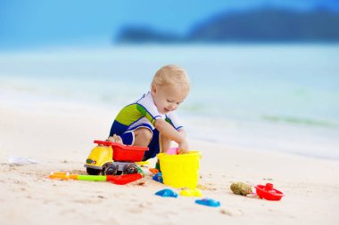 Çocuklar tropik sahilde oynar. Kum ve su oyuncak.