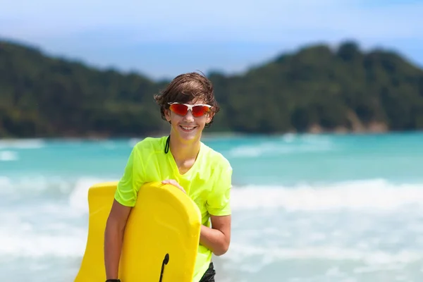 Szörfös trópusi tengerparton. Fiú, szörfözés. — Stock Fotó