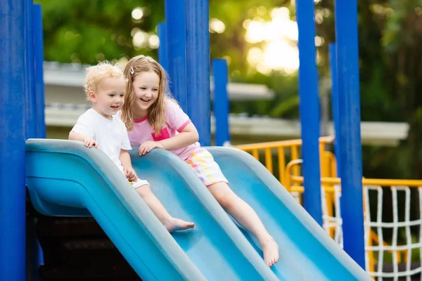 Crianças no parque infantil. Crianças brincam no parque de verão . — Fotografia de Stock