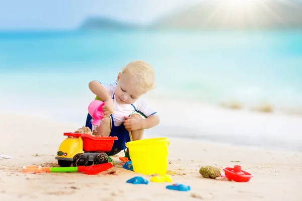 子供たちは、熱帯のビーチで遊ぶ。砂と水のグッズ. — ストック写真