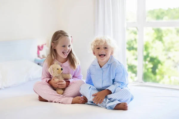 Τα παιδιά στο κρεβάτι. Τα παιδιά με τις πυτζάμες. Οικογενειακό δωμάτιο. — Φωτογραφία Αρχείου