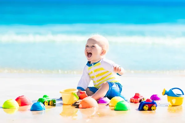 Bebê brincando na praia tropical cavando na areia — Fotografia de Stock