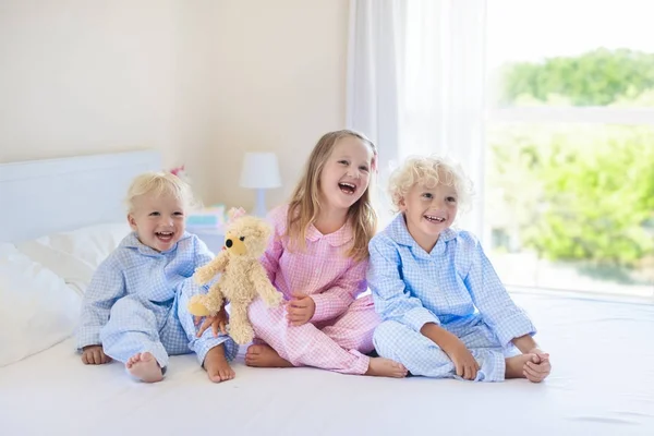 Niños en la cama. Niños en pijama. Dormitorio familiar . —  Fotos de Stock