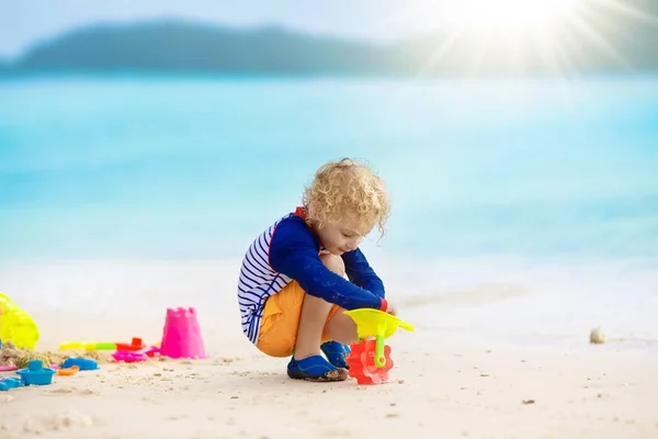 Kinderen spelen op tropisch strand. Zand en water speelgoed. — Stockfoto