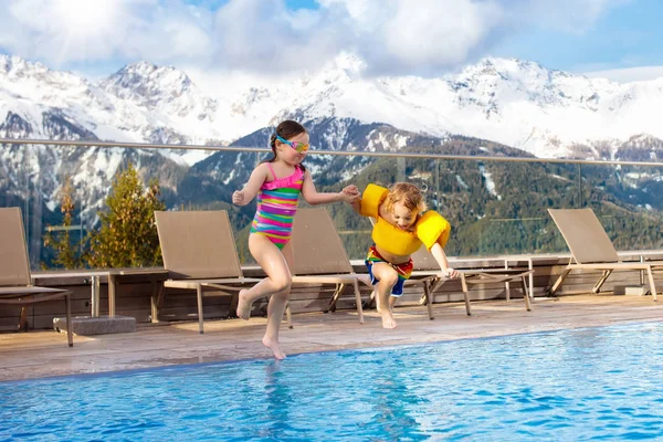 Kids in outdoor swimming pool of Alpine resort