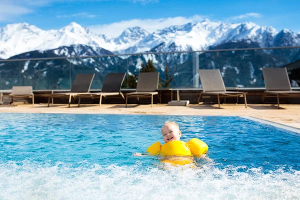 Child in outdoor swimming pool of alpine resort — Stock Photo, Image