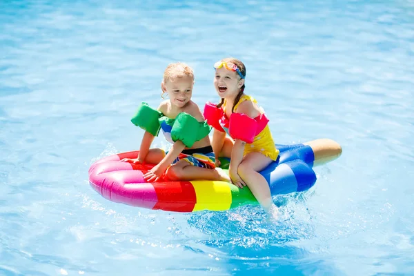 Kinderen op opblaasbare float in zwembad. — Stockfoto