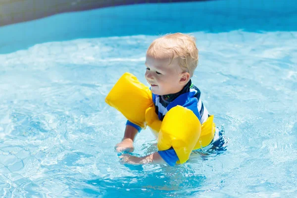 Bebê com braçadeiras infláveis na piscina . — Fotografia de Stock