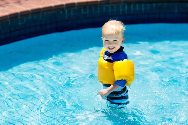 Bebê com braçadeiras infláveis na piscina . — Fotografia de Stock