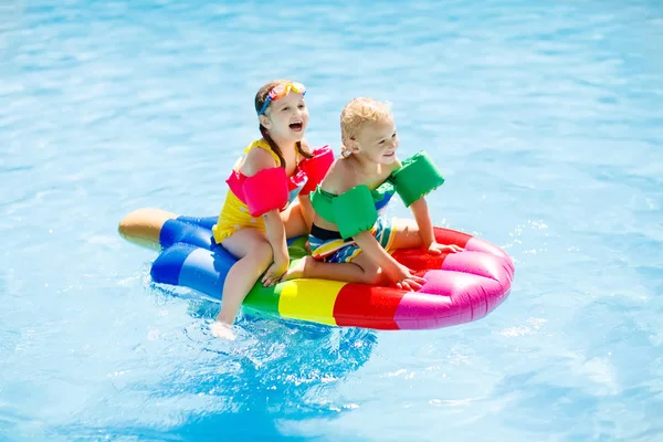 Kinderen op opblaasbare float in zwembad. — Stockfoto