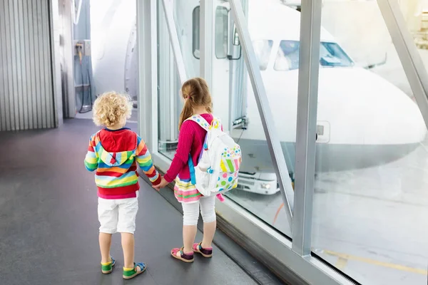 Los niños viajan y vuelan. Niño en el avión en el aeropuerto — Foto de Stock