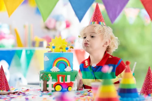 Barn födelsedagsfest. Barn som blåser ut tårta ljus — Stockfoto