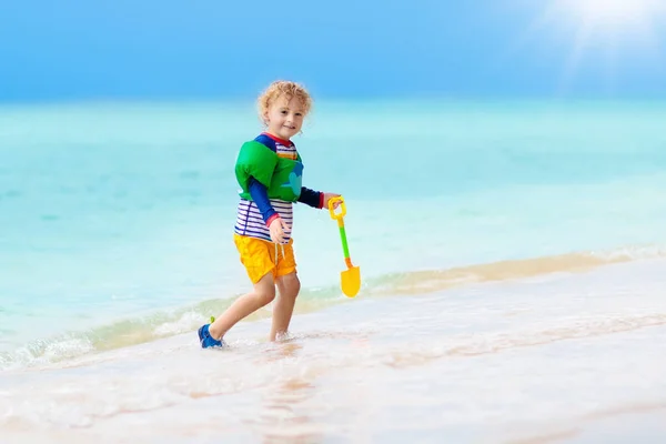 As crianças brincam na praia tropical. Brinquedo de areia e água . — Fotografia de Stock