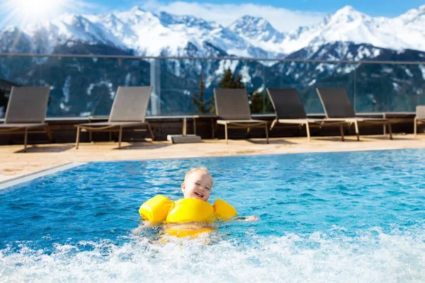 Child in outdoor swimming pool of alpine resort