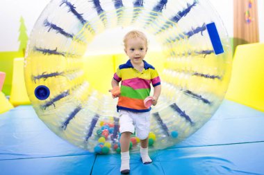 Çocuk oyun silindir tekerlek içinde. Trambolin üzerinde çocuklar. 