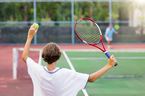 Enfant jouant au tennis sur un court extérieur — Photo