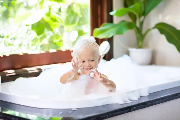 Kind im Schaumbad. Kinderbaden. Baby unter der Dusche. — Stockfoto