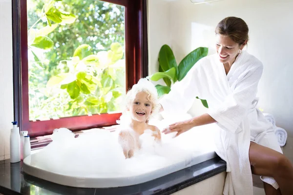 Мати миє дитину в бульбашковій ванні. Вода веселощі . — стокове фото