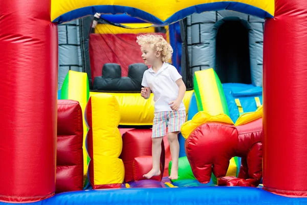 Bambino che salta sul trampolino del parco giochi. I bambini saltano . — Foto Stock