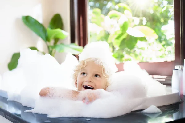 Kind im Schaumbad. Kinderbaden. Baby unter der Dusche. — Stockfoto