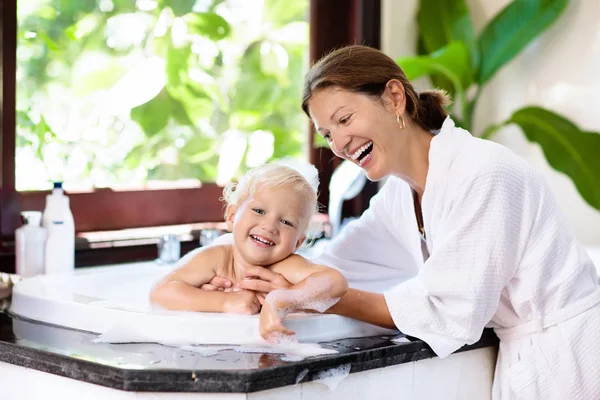 Mother washing baby in bubble bath. Water fun. — Stock Photo, Image