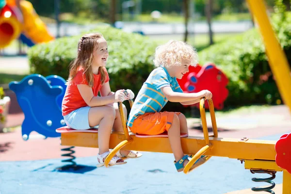 A gyerekek a játszótéren. Gyermekek játszanak nyári park. — Stock Fotó