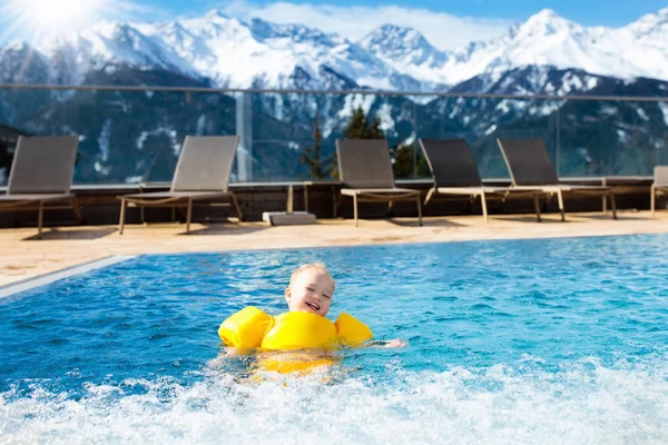 Child in outdoor swimming pool of alpine resort — Stock Photo, Image