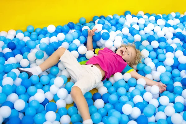 Los niños juegan en el hoyo. Niño jugando en la piscina bolas —  Fotos de Stock