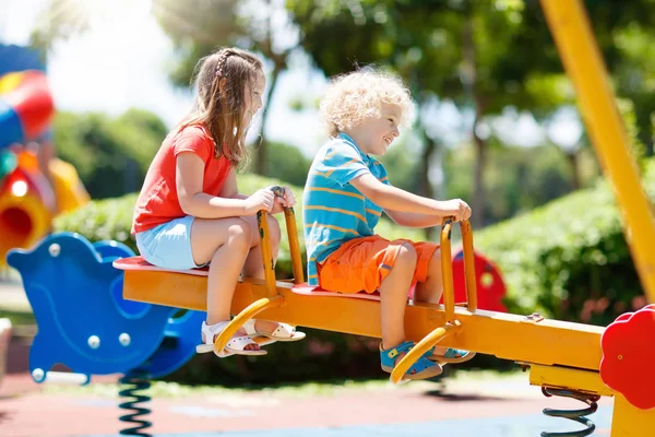Дети на детской площадке. Дети играют в летнем парке . — стоковое фото