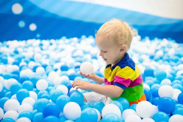 As crianças jogam em um poço de bolas. Criança brincando na piscina bolas — Fotografia de Stock