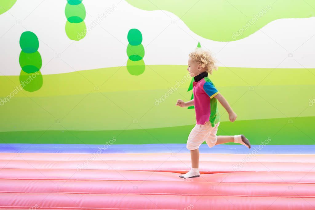 Child jumping on playground trampoline. Kids jump.