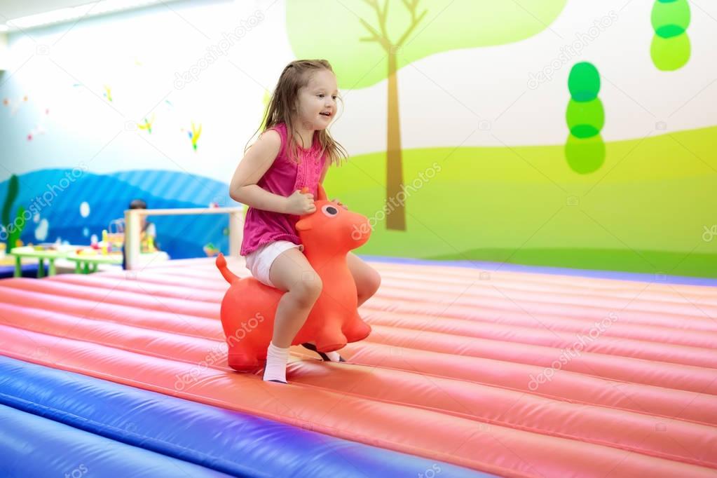Child jumping on playground trampoline. Kids jump.