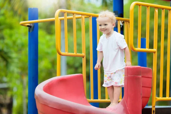 Bambini al parco giochi. I bambini giocano nel parco estivo . — Foto Stock