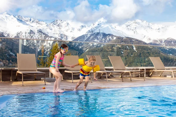 Kids in outdoor swimming pool of Alpine resort — Stock Photo, Image