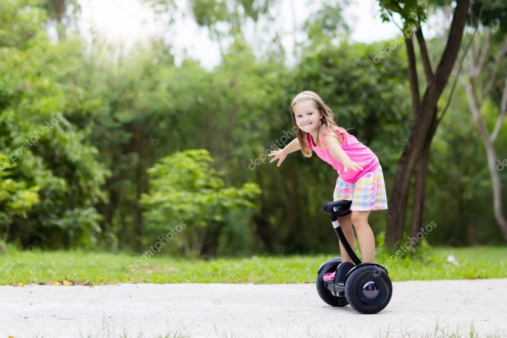 Child on hover board. Kids riding scooter