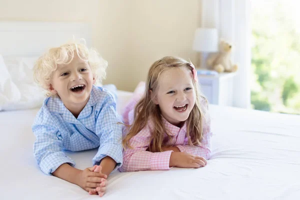 Miúdos na cama. Crianças de pijama. Quarto de família . — Fotografia de Stock