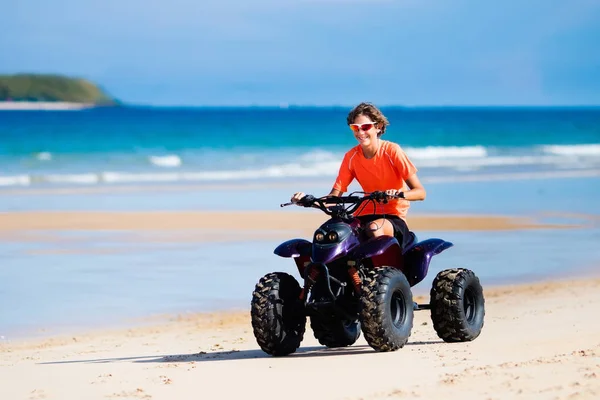 Adolescente equitazione quad sulla spiaggia — Foto Stock