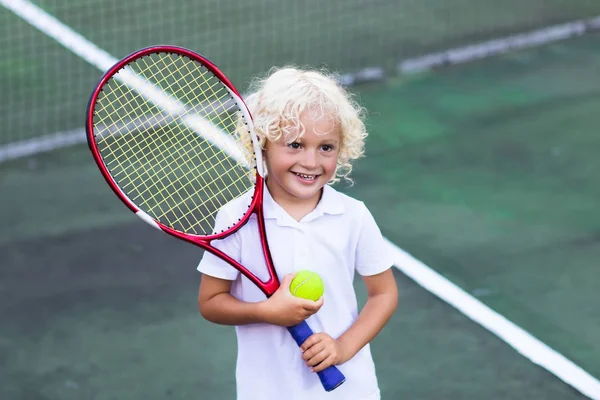 Dítě hrající tenis na venkovní kurt — Stock fotografie