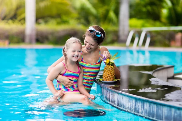 Madre e hijo beben jugo en la piscina — Foto de Stock