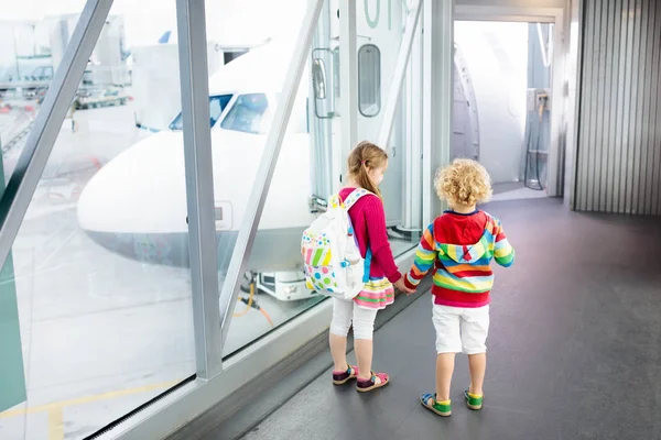 Дети путешествуют и летают. Ребенок в самолете в аэропорту — стоковое фото