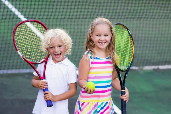 Niños jugando tenis en la cancha al aire libre —  Fotos de Stock