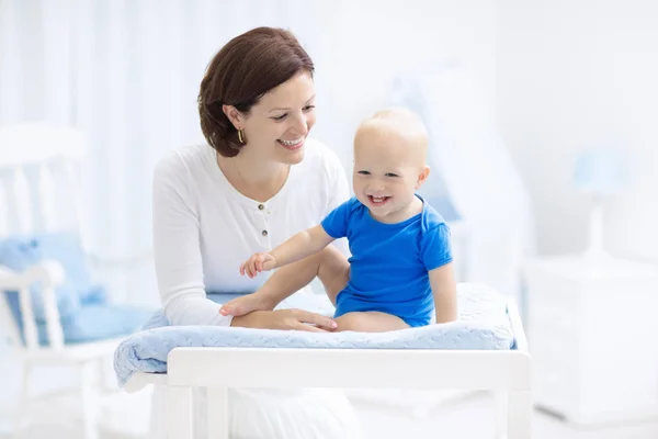 Mãe e bebê em mudança de mesa — Fotografia de Stock