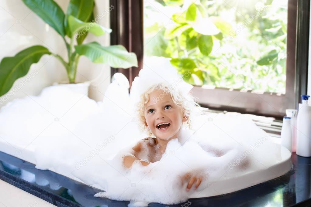 Child in bubble bath. Kid bathing. Baby in shower.