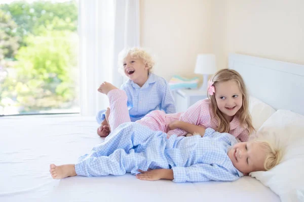 Kids in bed. Children in pajamas. Family bedroom.