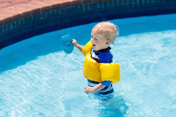 Bebê com braçadeiras infláveis na piscina . — Fotografia de Stock