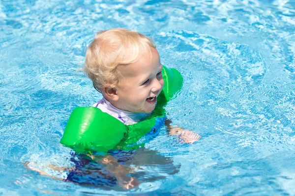 Bebê com braçadeiras infláveis na piscina . — Fotografia de Stock