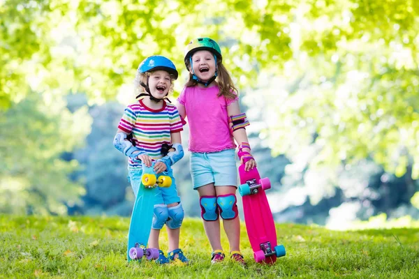 Niños montando monopatín en el parque de verano —  Fotos de Stock