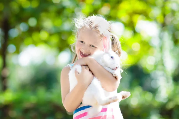 Child with rabbit. Easter bunny. Kids and pets.