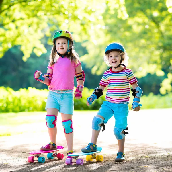 Children riding skateboard in summer park — Stock Photo, Image